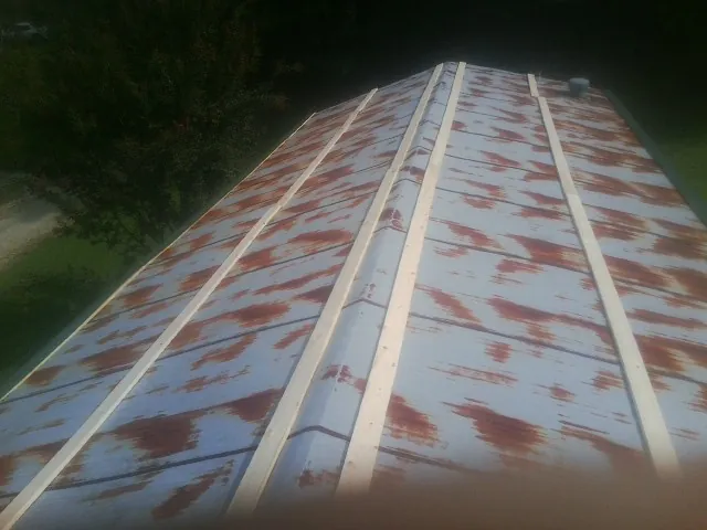 Rusted metal roof panels with new wood purlins before replacement — Storm Damage Roof Repair in Abell by Roofing Brothers