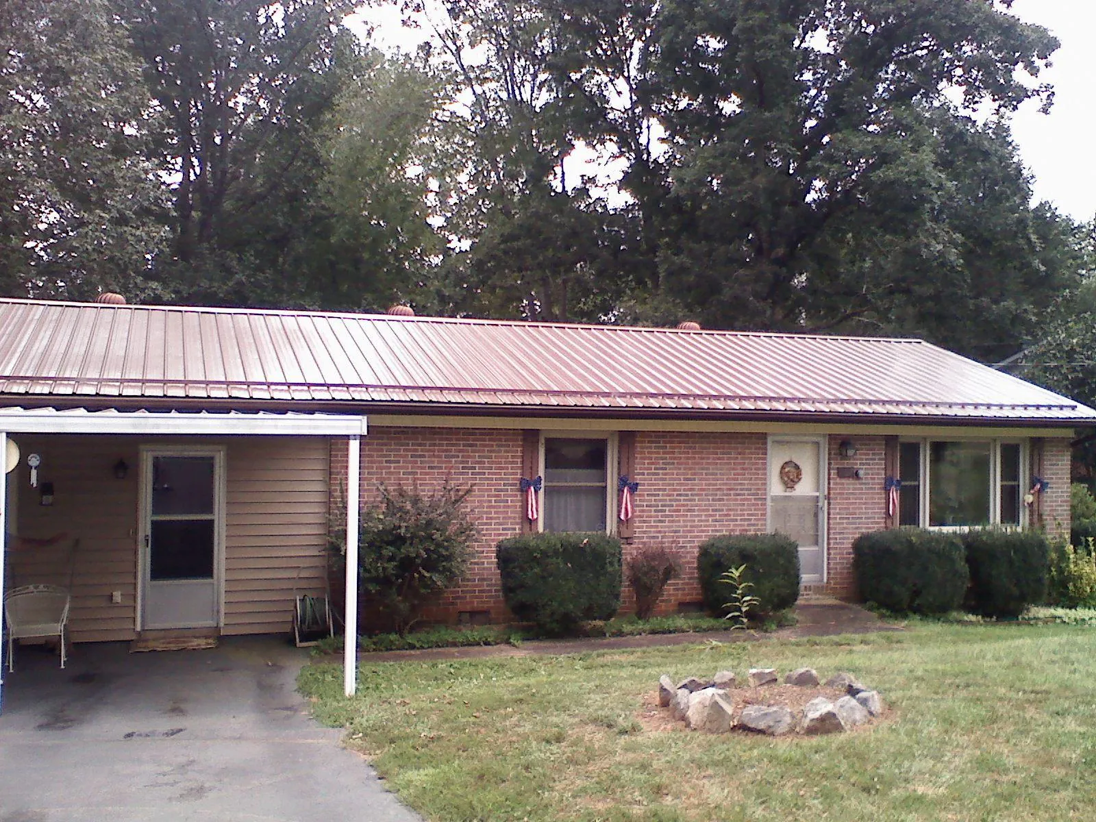 Bronze metal roof and carport on a brick ranch home — Roof Repair work by our crew in Abell